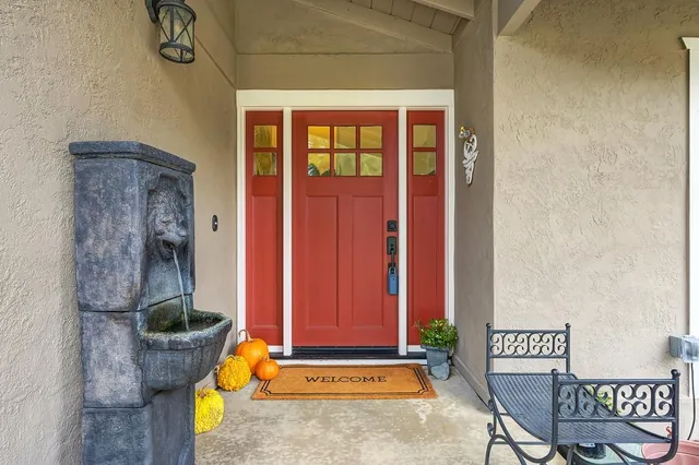 a living room with furniture a rug a lamp and a fireplace