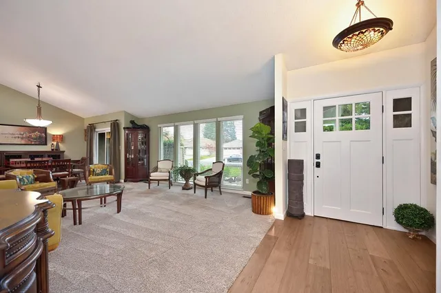 a living room with fireplace furniture and a large window