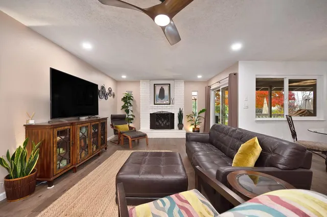 a large white kitchen with a large window a stove and a chandelier