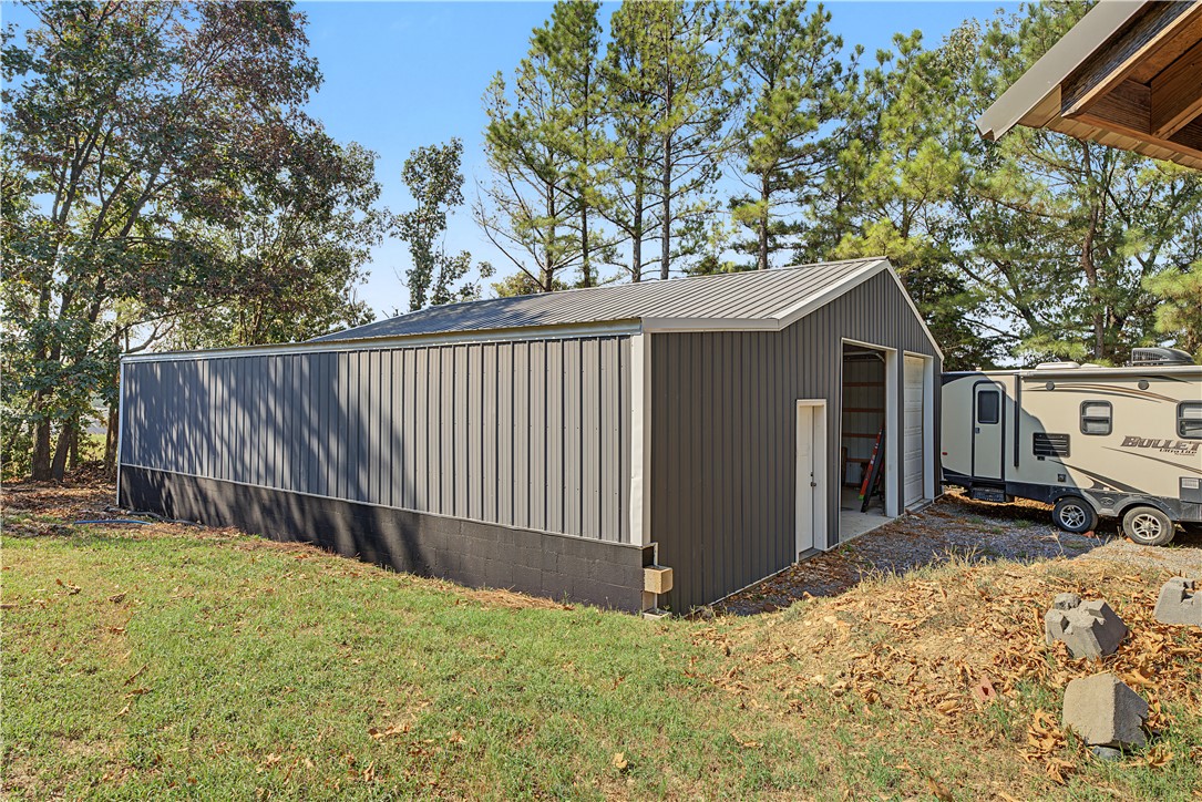 15282 Burgin Valley Road Gravette, AR 72736 - Photo 29 of 53 Detached structure featuring a metal roof, corrugated metal siding, and a roll-up garage door