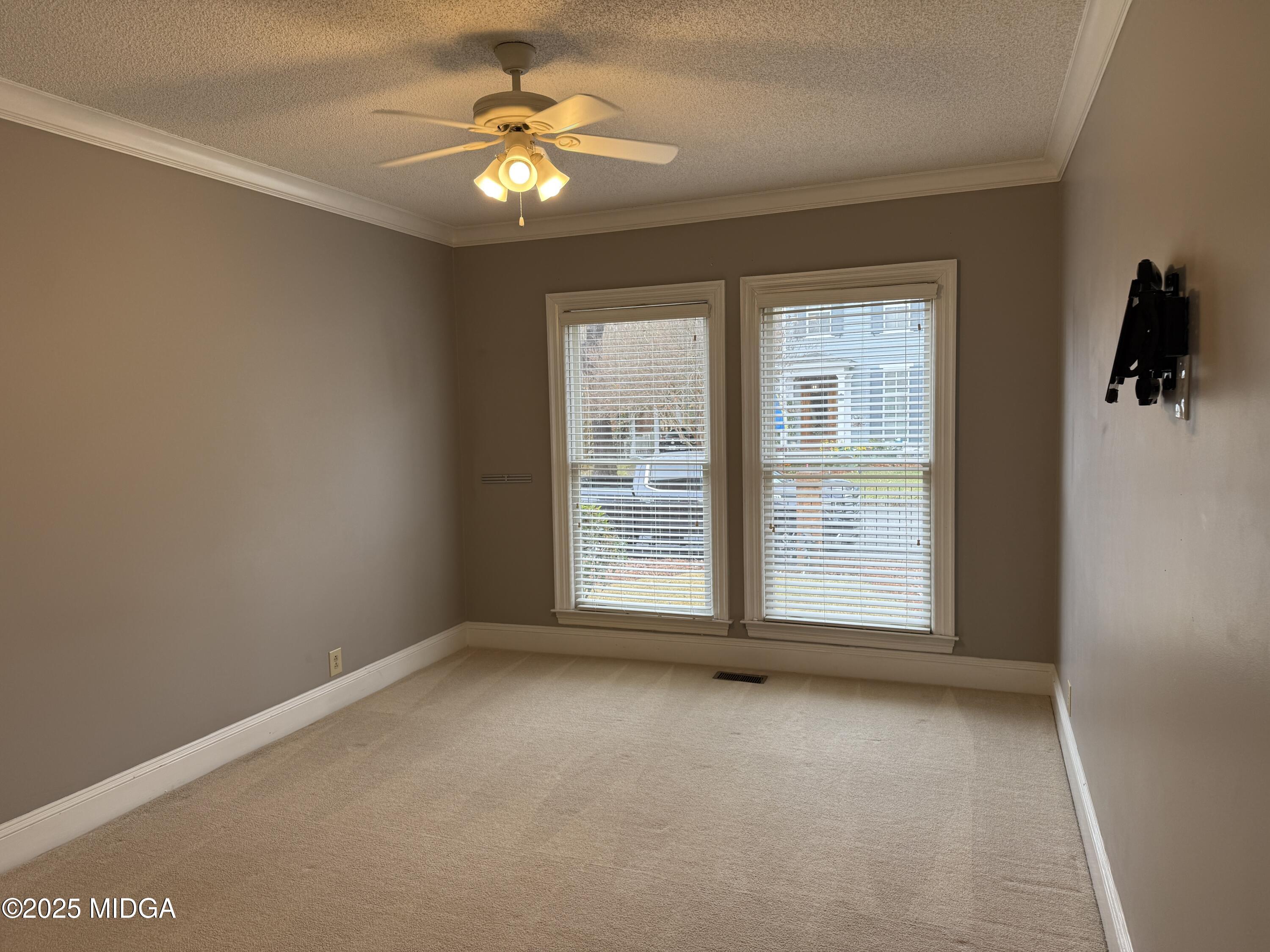 175 Corbin Avenue, Unit A Macon, GA 31204 - Photo 12 of 15 an empty room with chandelier fan and windows