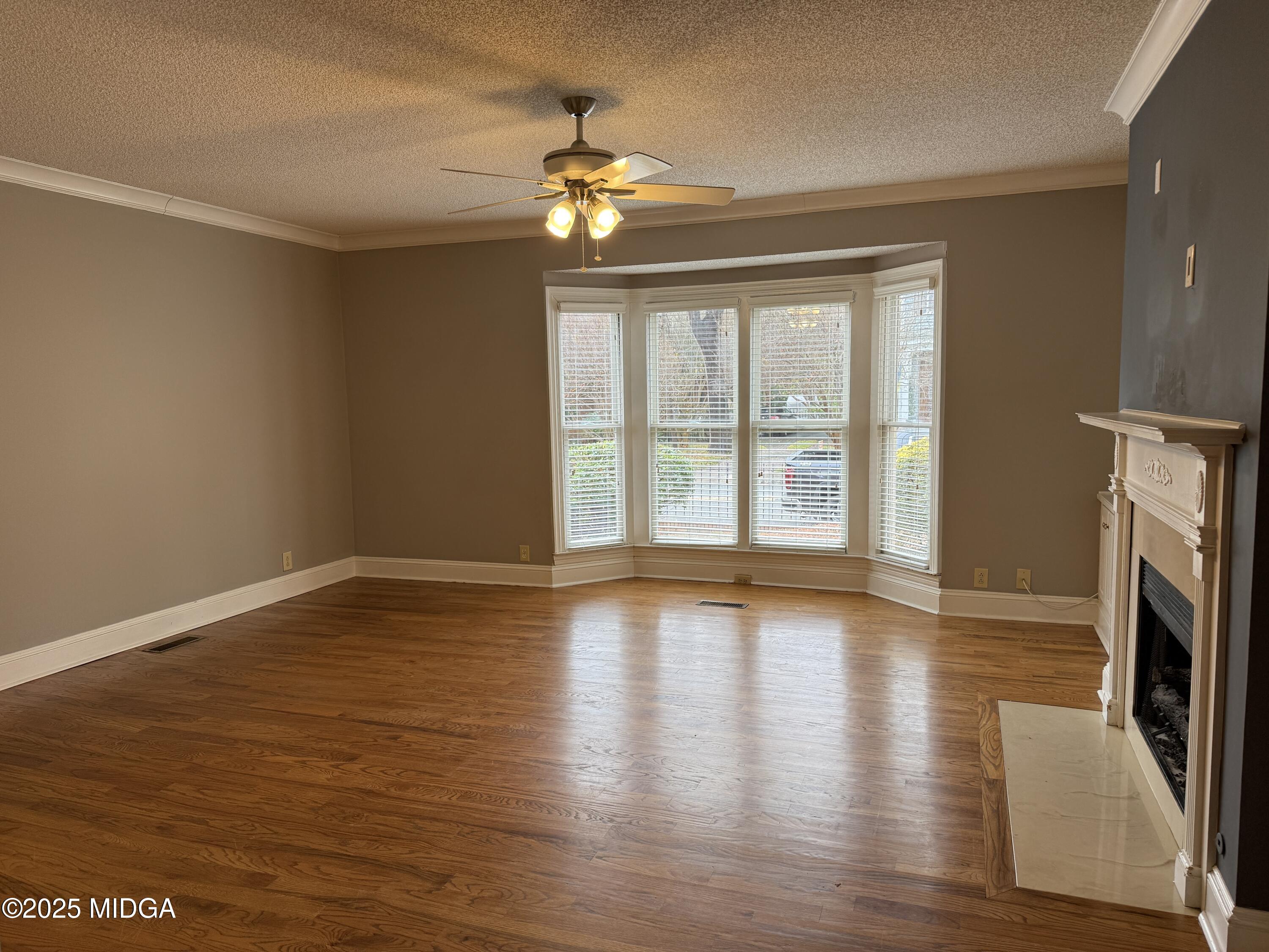 175 Corbin Avenue, Unit A Macon, GA 31204 - Photo 3 of 15 a view of an empty room with wooden floor and a window