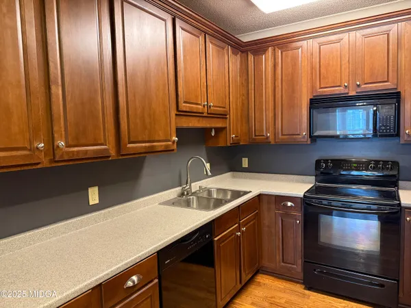 a kitchen with stainless steel appliances granite countertop a sink a stove and a microwave