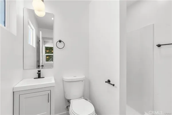 a bathroom with a toilet a sink and mirror