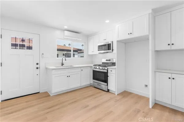 a kitchen with white cabinets and white appliances