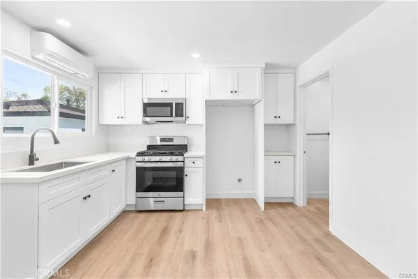 a kitchen with stainless steel appliances a stove a sink and a refrigerator