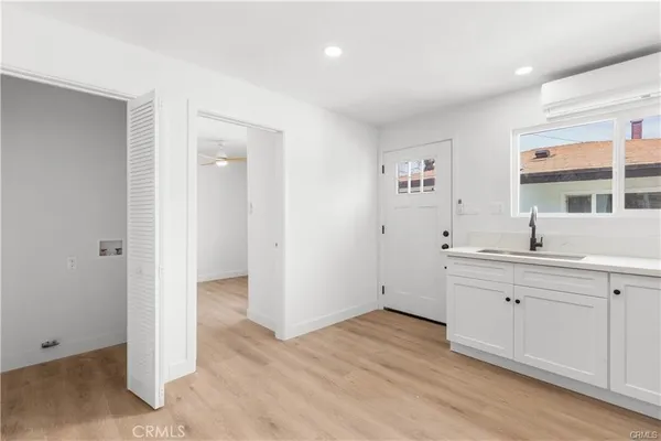 a view of cabinets a sink and wooden floor in a room