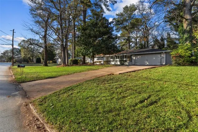 a view of a house with a backyard and a tree