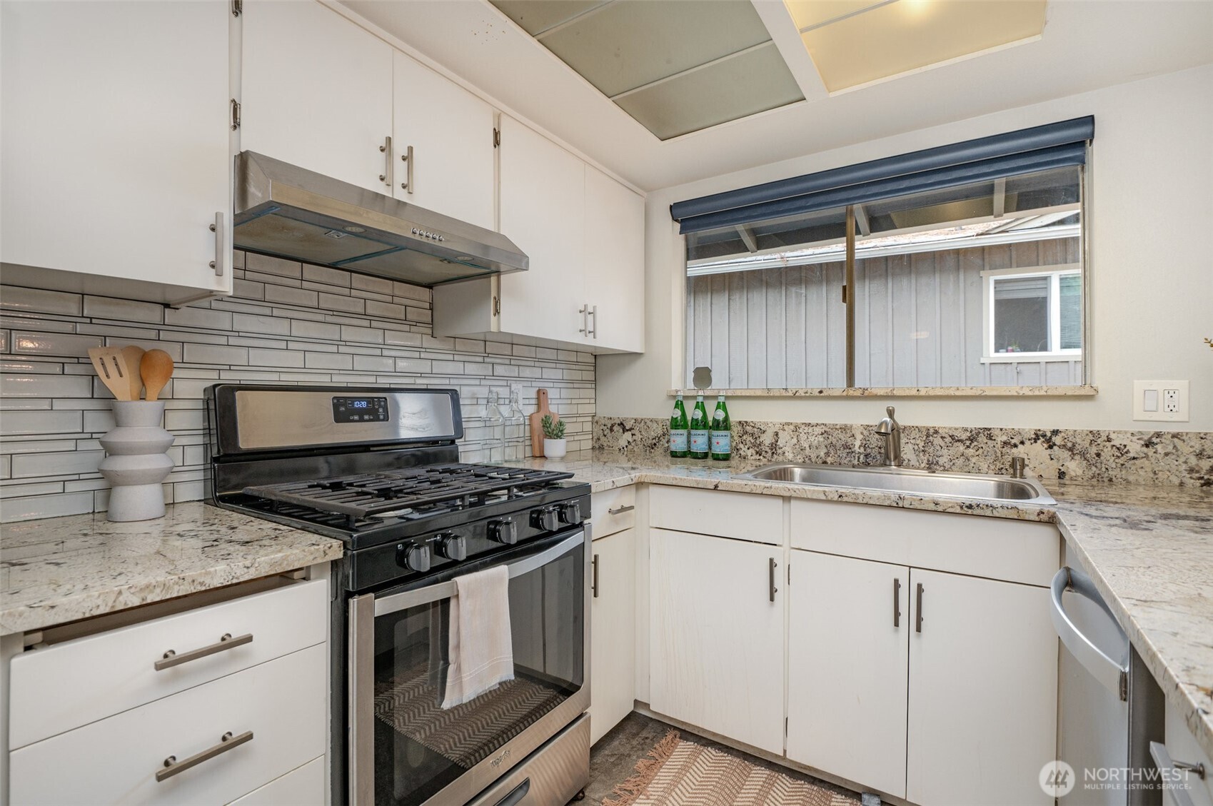 11804 Southeast 165th Street Renton, WA 98058 - Photo 10 of 28 a kitchen with granite countertop stainless steel appliances a stove sink and cabinets