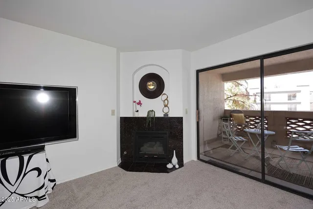 a living room with furniture a flat screen tv and a floor to ceiling window
