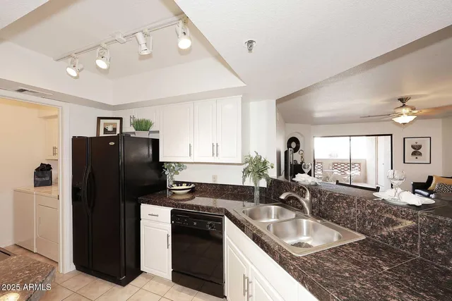 a kitchen with granite countertop a refrigerator and a sink