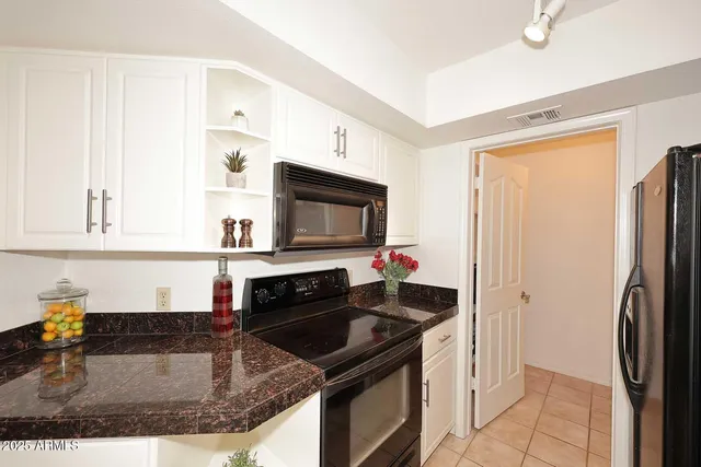 a kitchen with granite countertop a refrigerator stove and sink