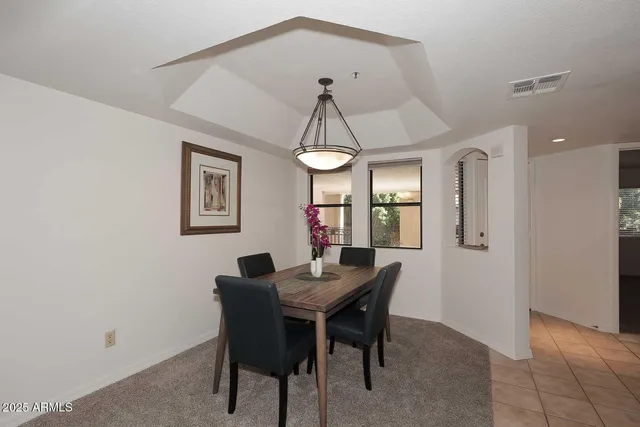 a dining room with wooden floor a chandelier a wooden table and chairs