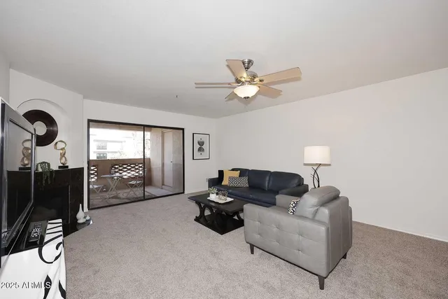 a living room with furniture a lamp and a flat screen tv