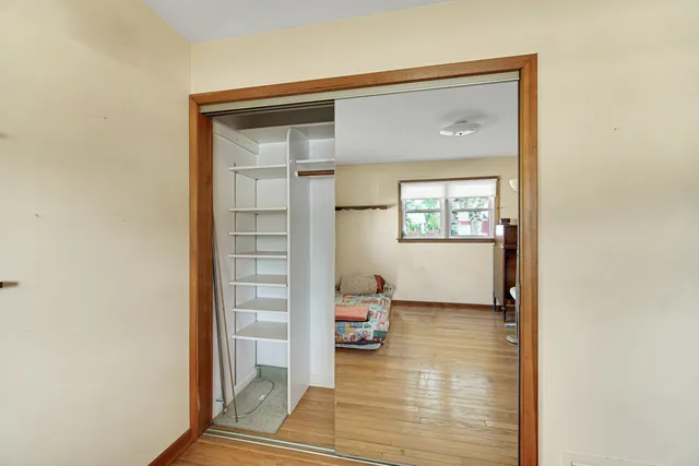 a bedroom with a bed and wooden floor