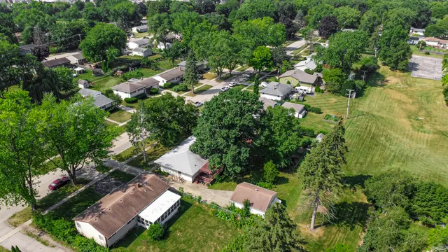 an aerial view of residential house with outdoor space and trees all around