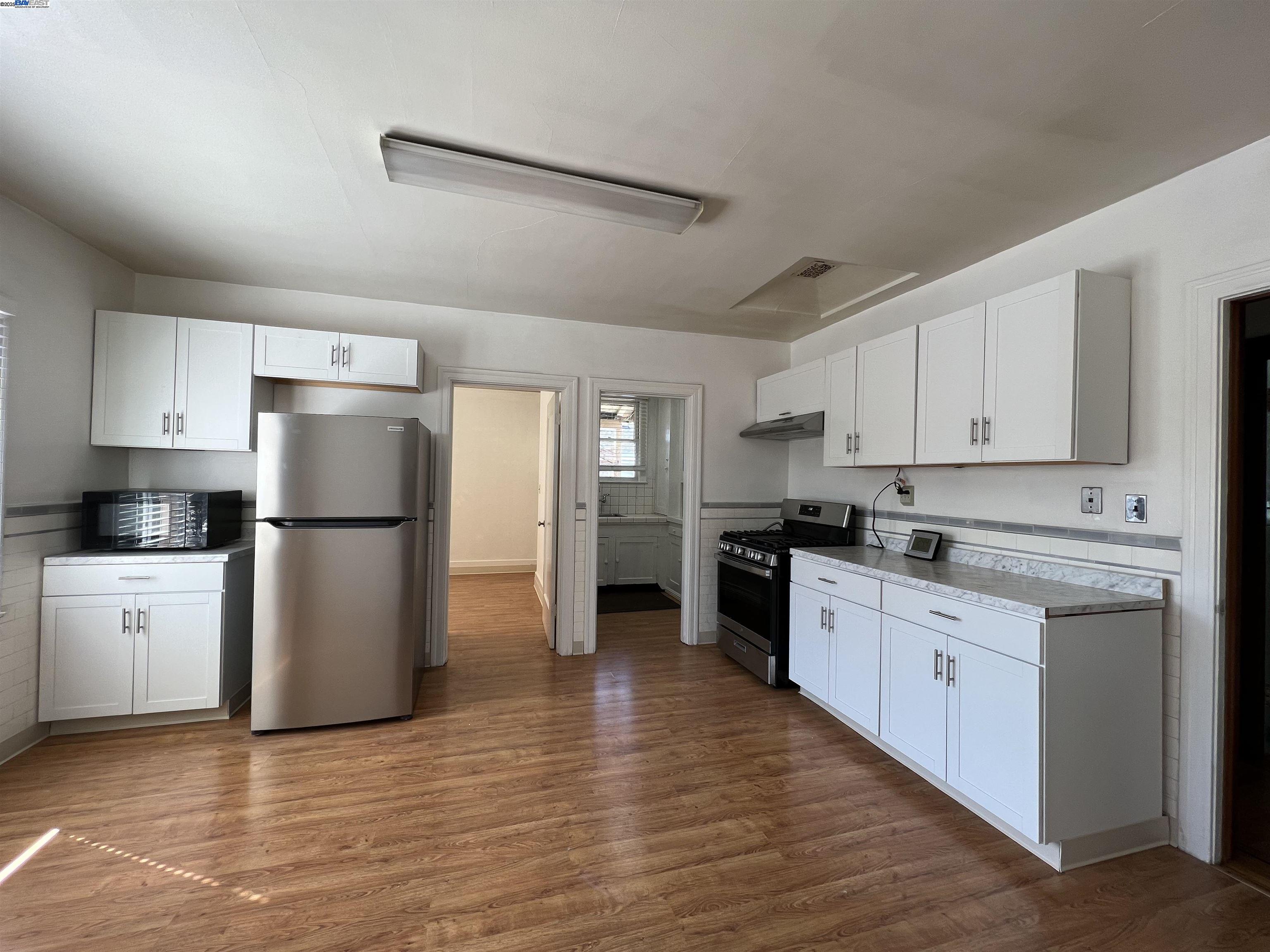 1301 9th Street Alameda, CA 94501 - Photo 4 of 12 a kitchen with granite countertop a refrigerator stove top oven and sink