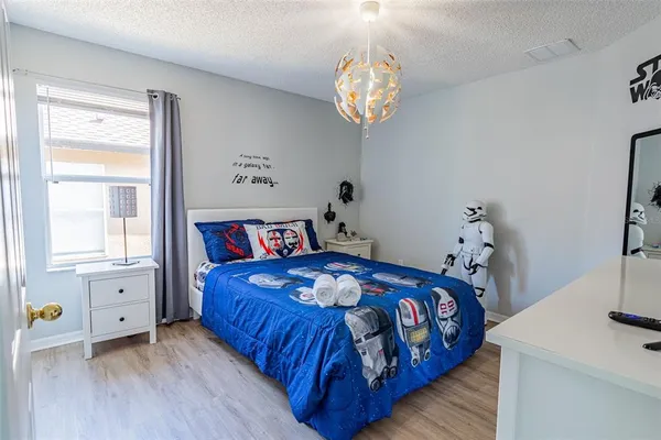 a bedroom that has a bed that has a blanket on it and next to a window