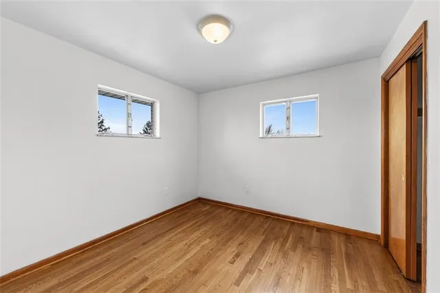 an empty room with wooden floor and closet