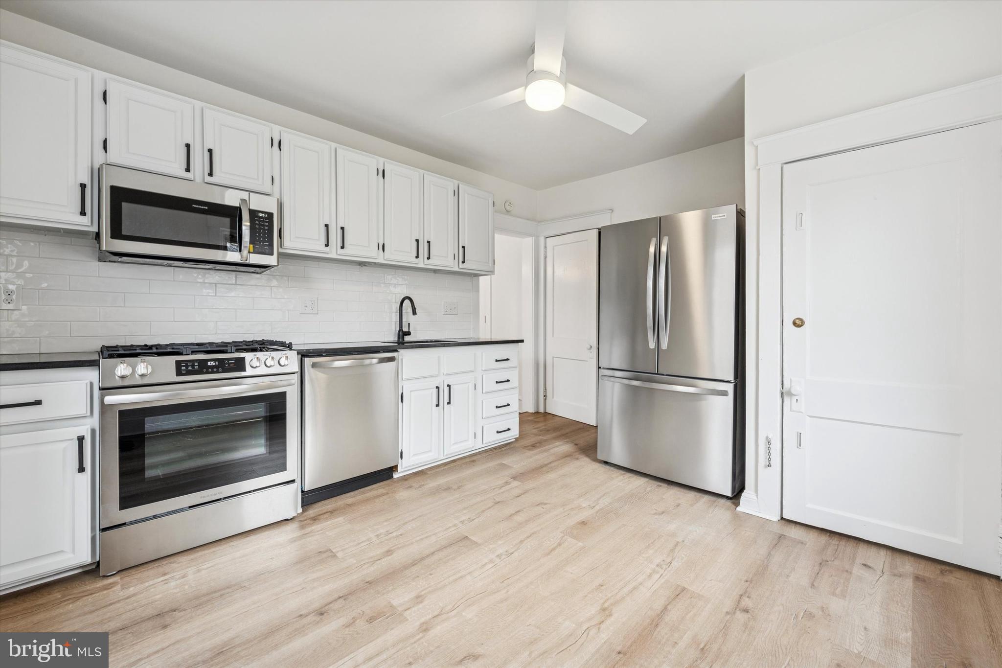 10 West Jefferson Street Media, PA 19063 - Photo 11 of 24 a kitchen with stainless steel appliances white cabinets white stove a microwave and a refrigerator
