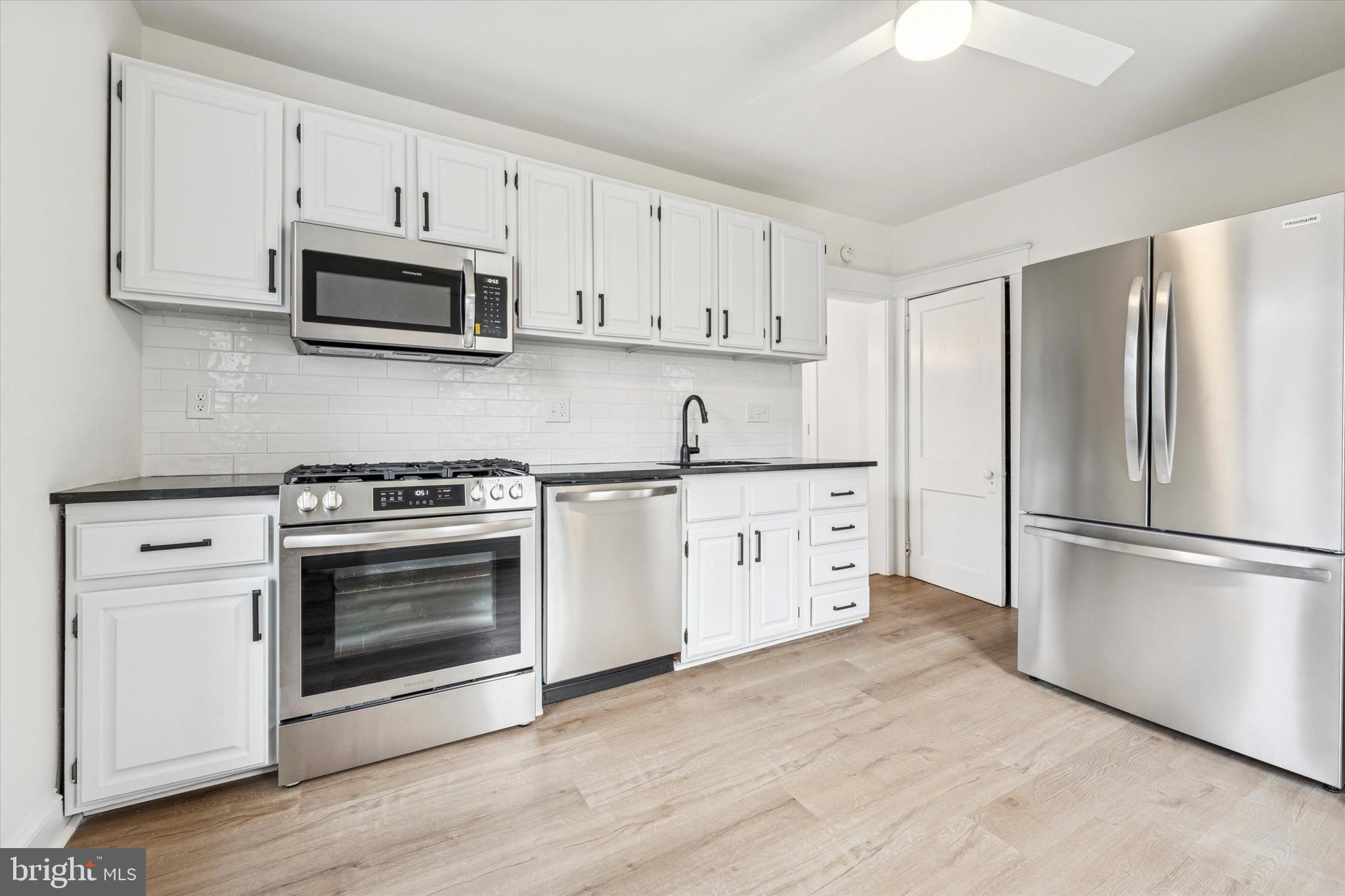 10 West Jefferson Street Media, PA 19063 - Photo 9 of 24 a kitchen with cabinets stainless steel appliances and wooden floor