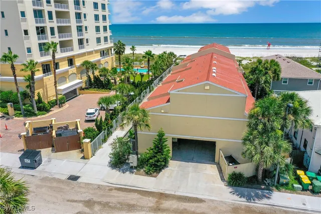 a front view of a house with a yard and potted plants