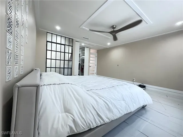 a bed sitting in a spacious bedroom next to a window