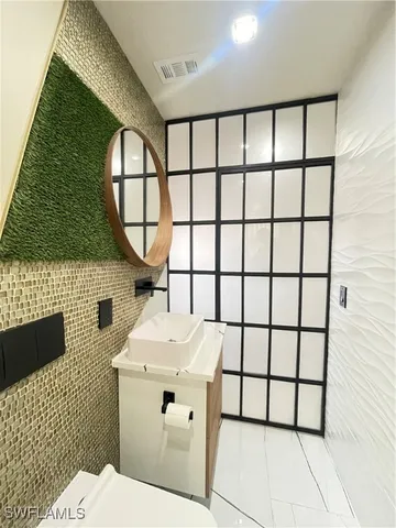 a bathroom with a sink toilet and mirror