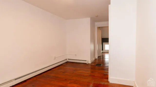a view of a room with wooden floor and window