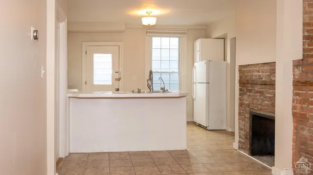 a view of kitchen with granite countertop cabinets and refrigerator