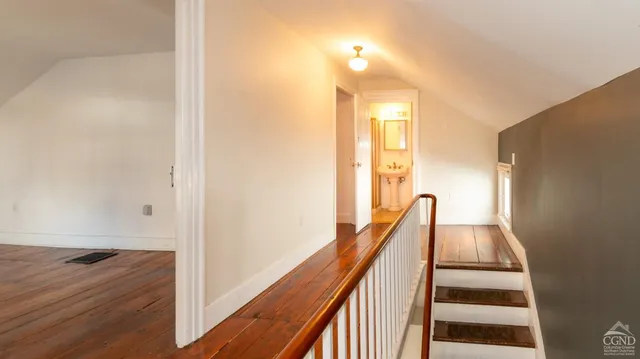 a view of a hallway with wooden floor and staircase