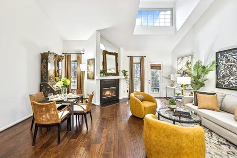 a living room with furniture fireplace and dining table