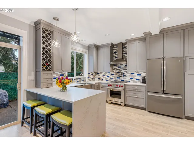 a kitchen with refrigerator and chairs