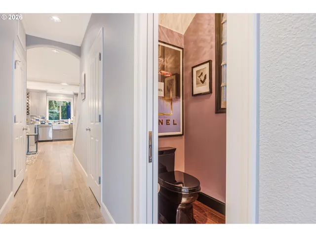 a view of a hallway with wooden floor and living room