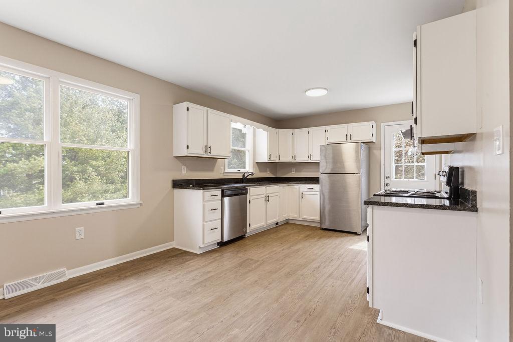 225 Bragg Circle Hanover, PA 17331 - Photo 8 of 32 a kitchen with a refrigerator a stove top oven and white cabinets