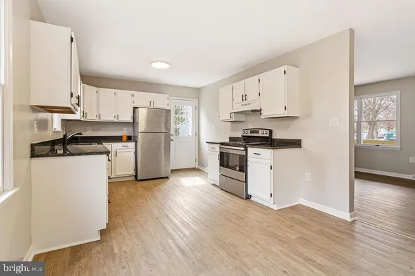 a kitchen with granite countertop white cabinets and white appliances