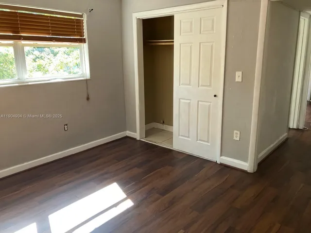 an empty room with wooden floor and closet