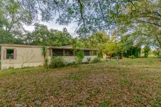 a view of a house with backyard and sitting area