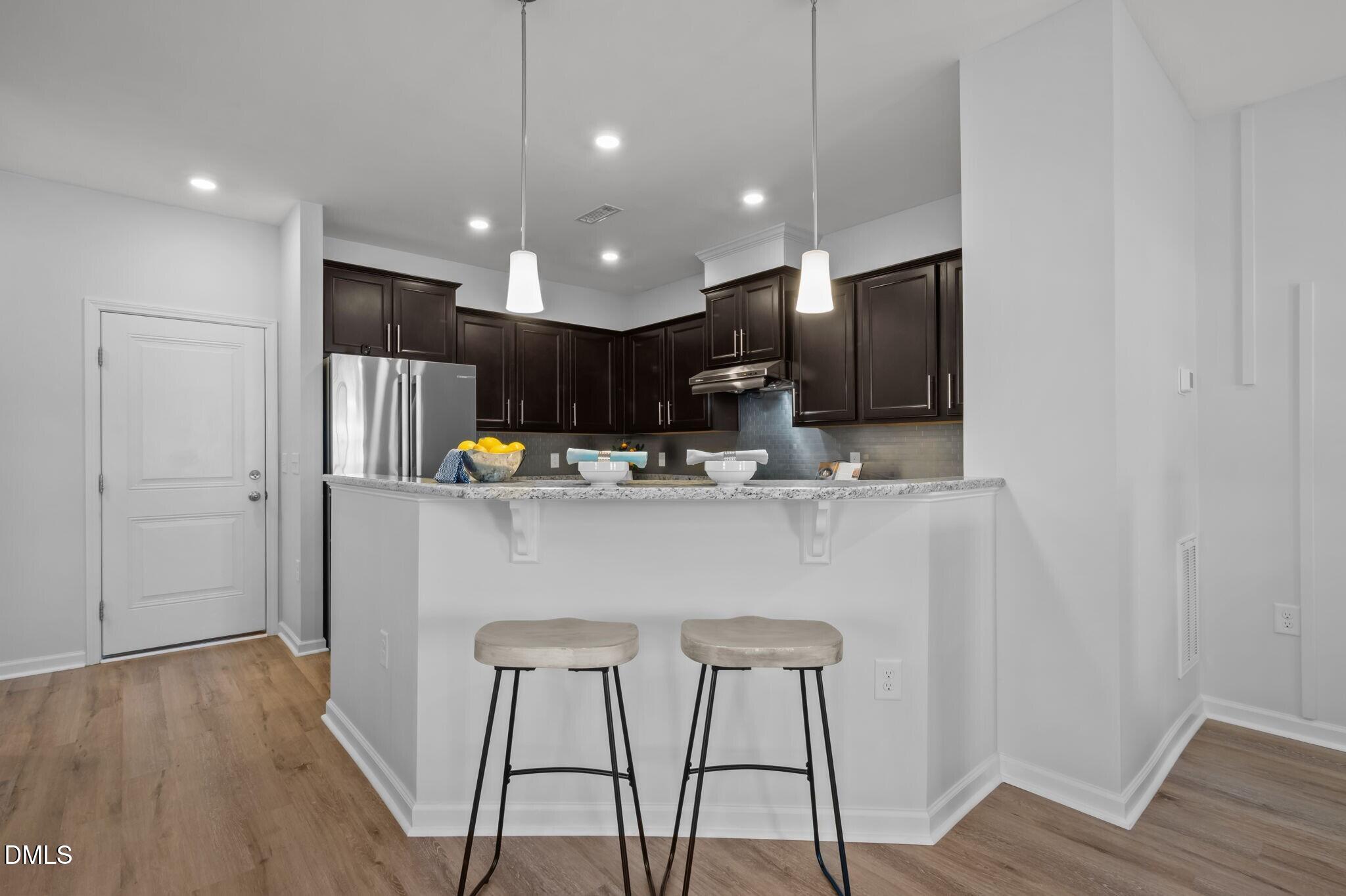 17 Rambler Lane Morrisville, NC 27560 - Photo 11 of 50 a kitchen with stainless steel appliances granite countertop a refrigerator a microwave oven a sink with island and chairs