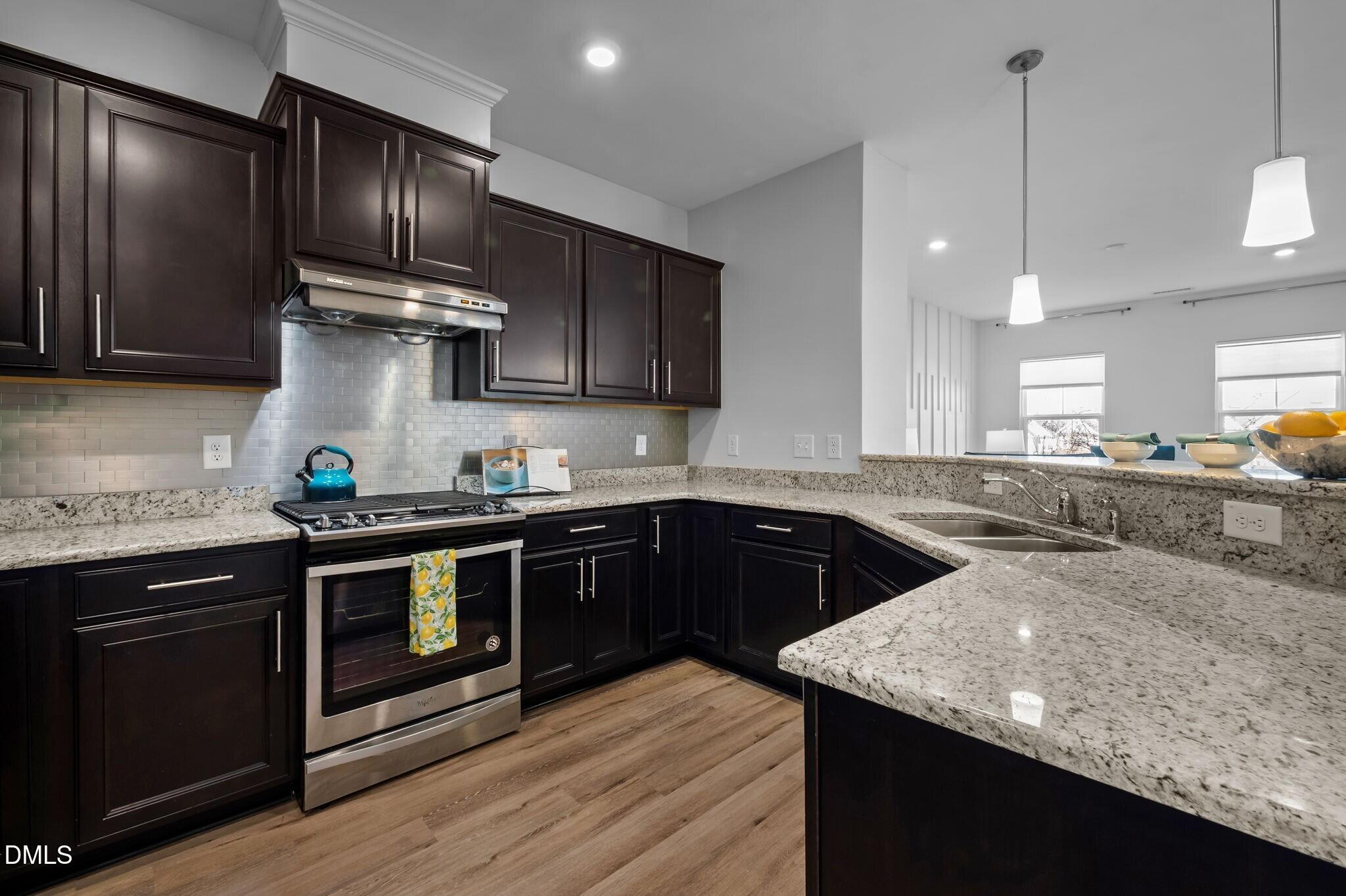 17 Rambler Lane Morrisville, NC 27560 - Photo 13 of 50 a kitchen with stainless steel appliances granite countertop wooden cabinets stove top oven and sink