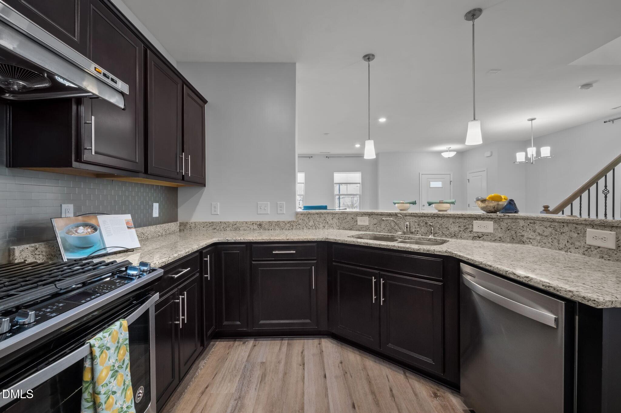 17 Rambler Lane Morrisville, NC 27560 - Photo 15 of 50 a kitchen with stainless steel appliances granite countertop a stove a sink and a microwave