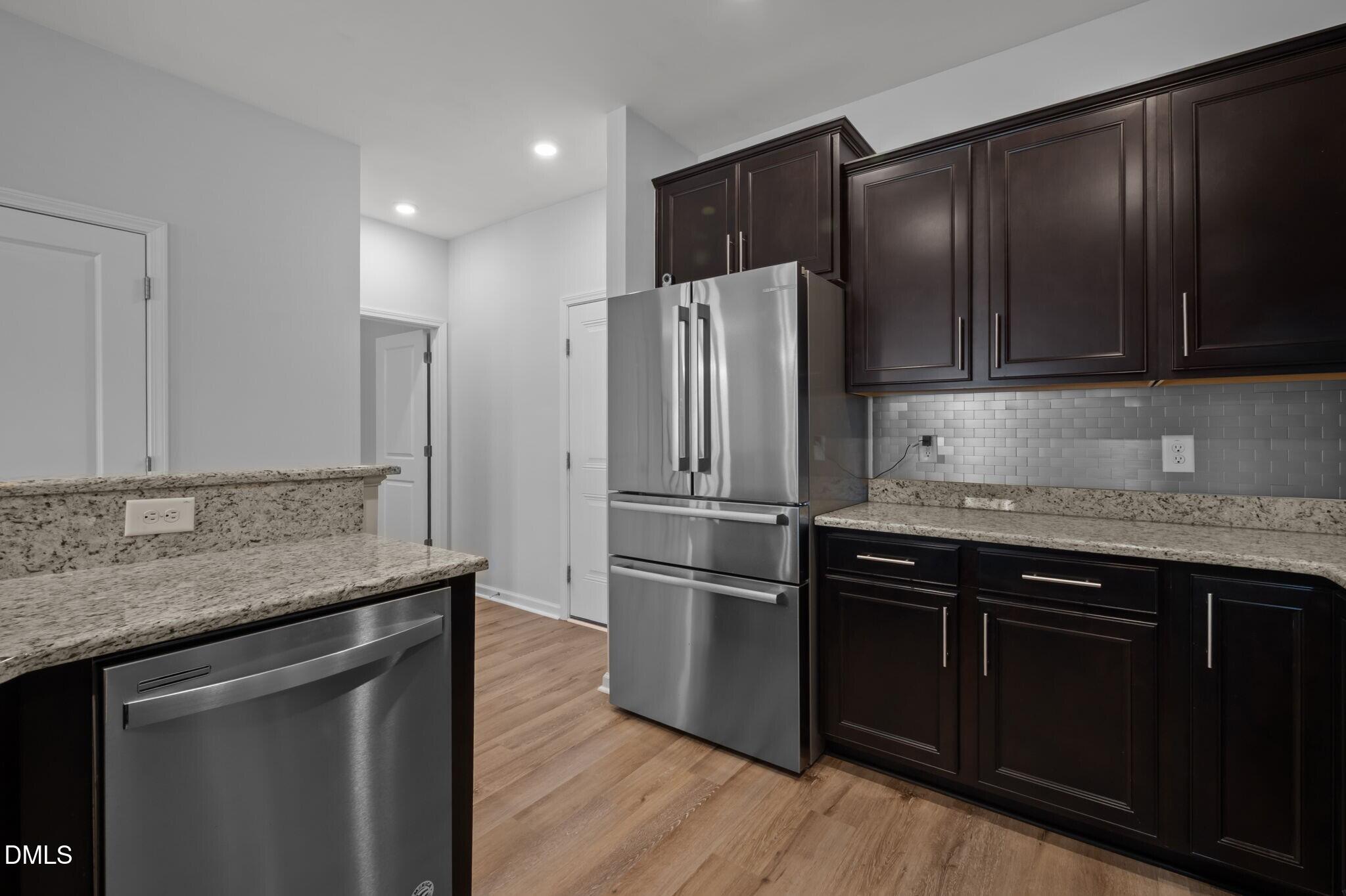 17 Rambler Lane Morrisville, NC 27560 - Photo 16 of 50 a kitchen with kitchen island granite countertop stainless steel appliances and wooden cabinets