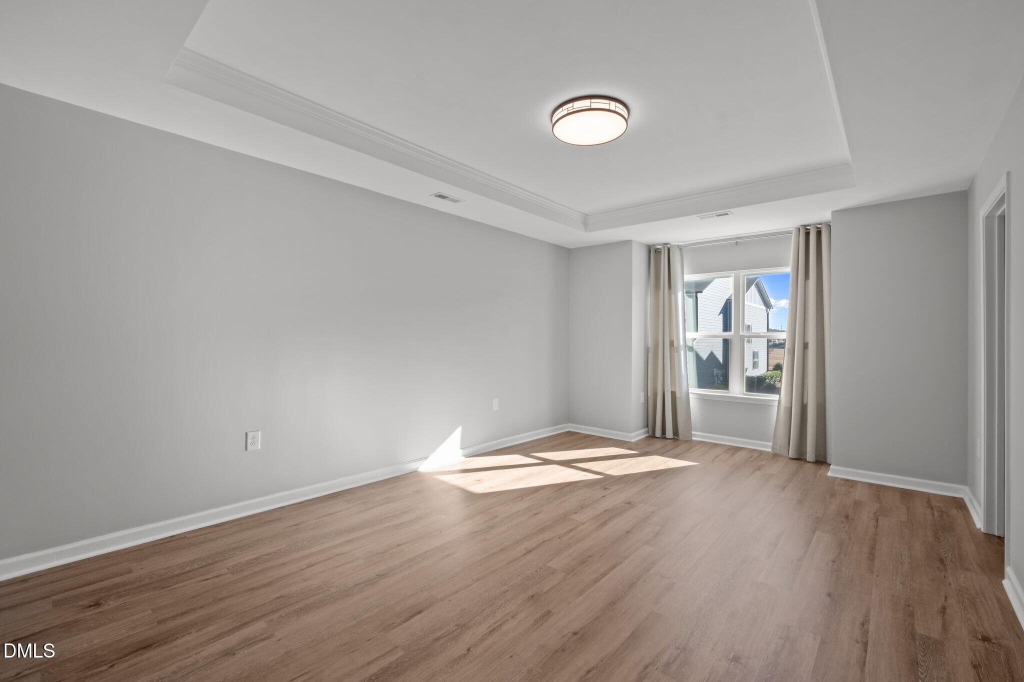 17 Rambler Lane Morrisville, NC 27560 - Photo 21 of 50 a view of an empty room with wooden floor and a window