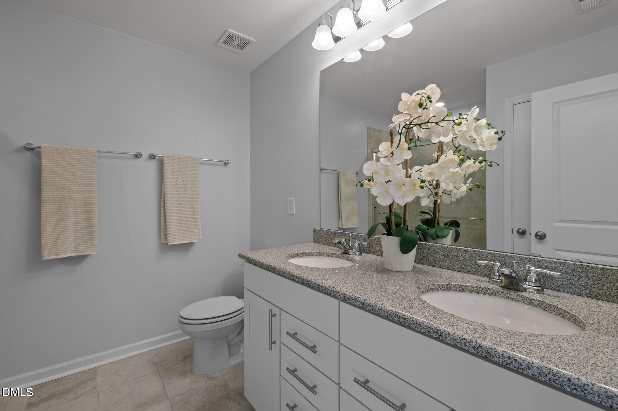 17 Rambler Lane Morrisville, NC 27560 - Photo 24 of 50 a bathroom with a granite countertop toilet sink and mirror
