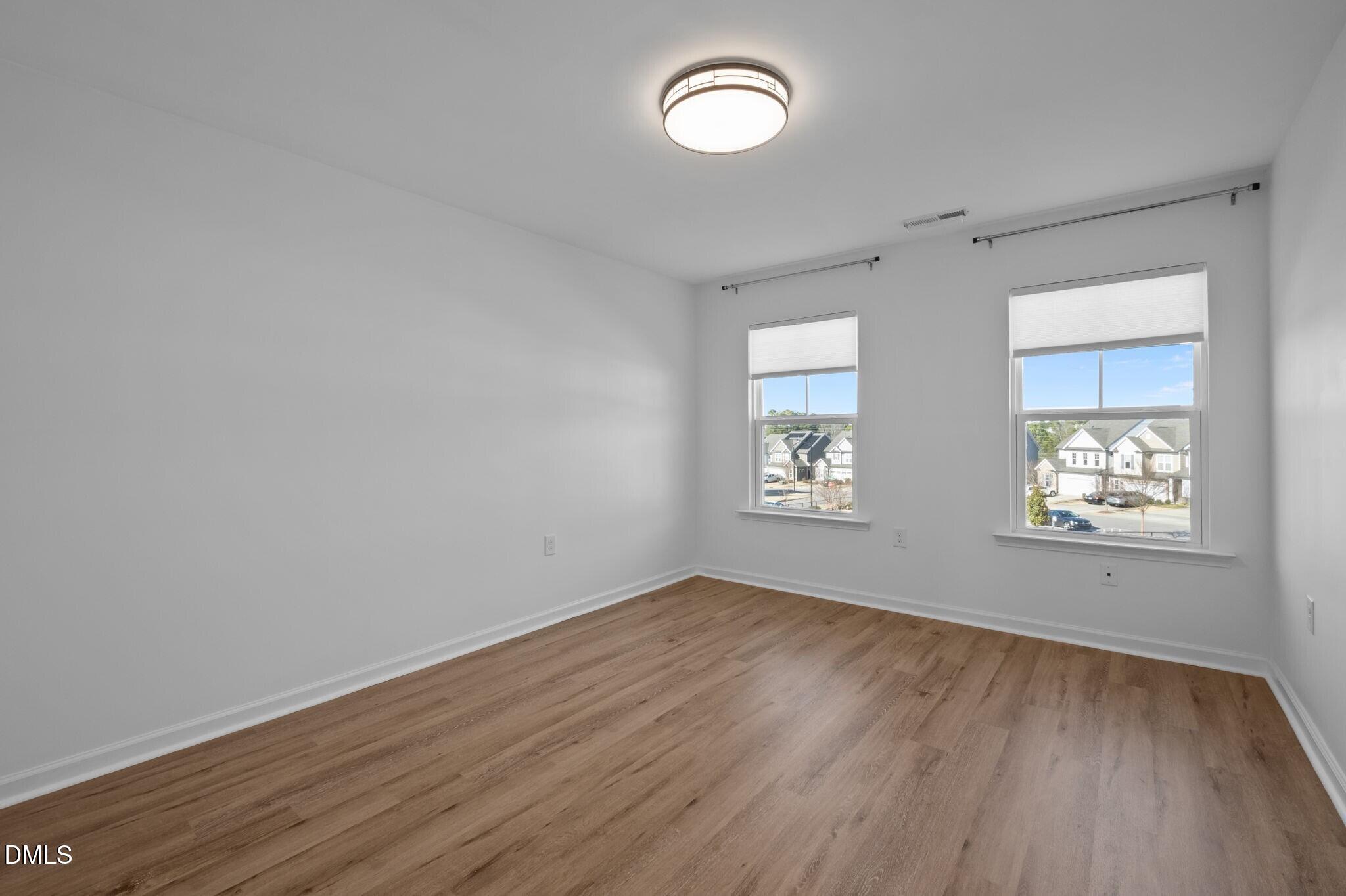17 Rambler Lane Morrisville, NC 27560 - Photo 27 of 50 an empty room with wooden floor and windows
