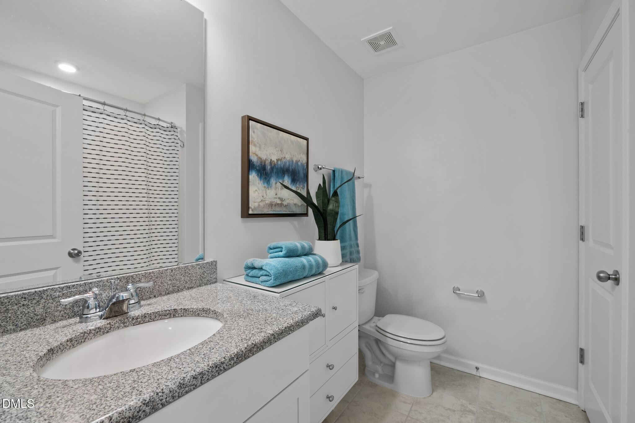 17 Rambler Lane Morrisville, NC 27560 - Photo 29 of 50 a bathroom with a granite countertop toilet sink and mirror