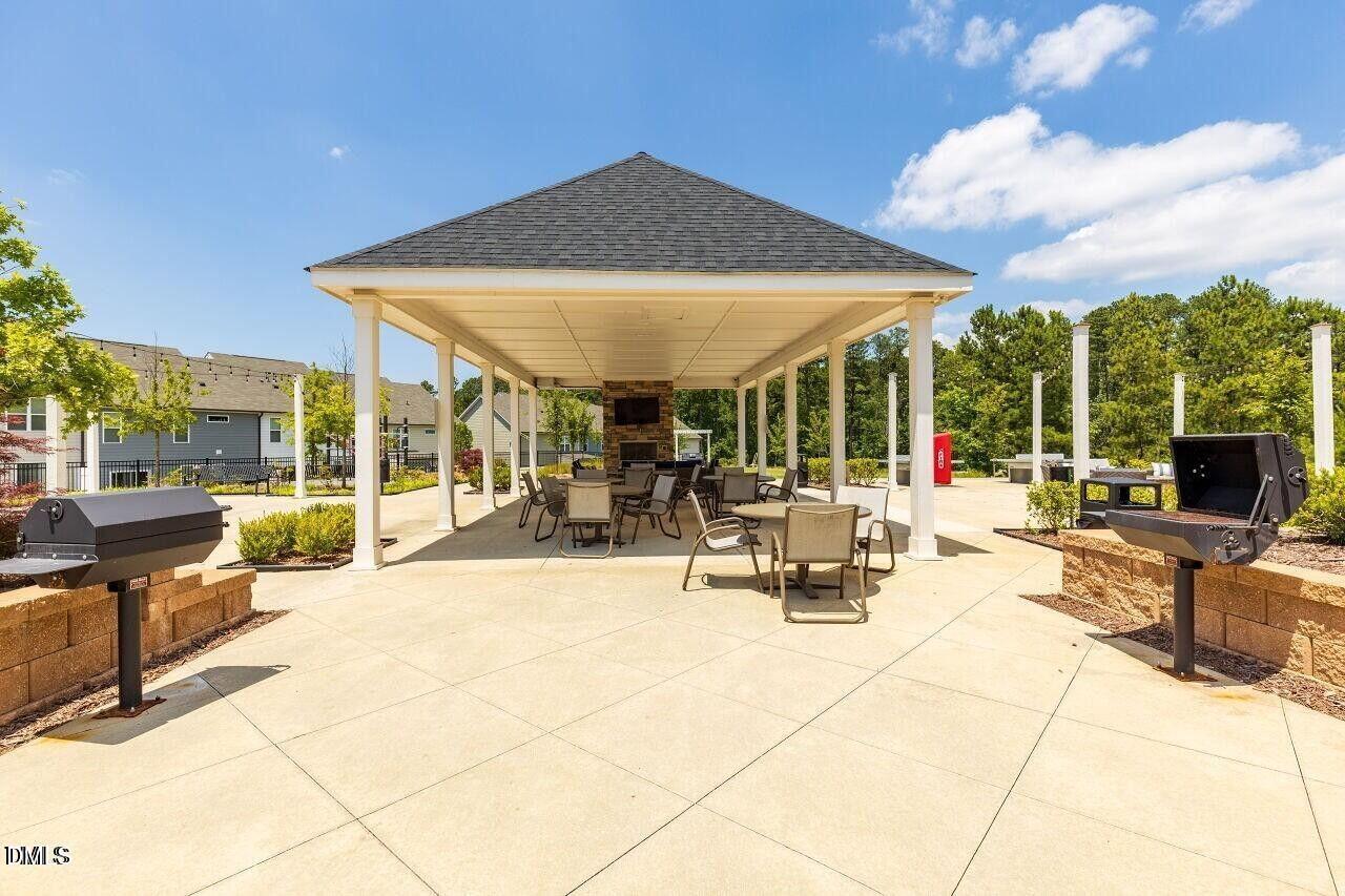 17 Rambler Lane Morrisville, NC 27560 - Photo 42 of 50 a view of the patio with dining table and chairs under an umbrella