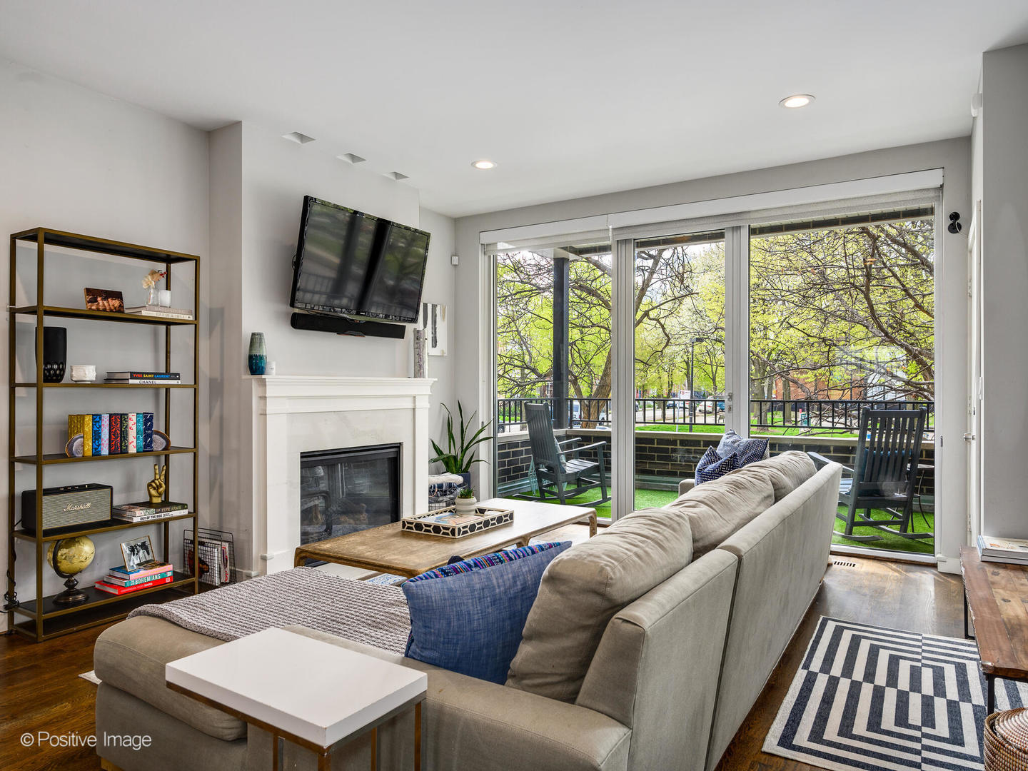 2235 North Oakley Avenue, Unit 1 Chicago, IL 60647 - Photo 3 of 27 a living room with fireplace furniture large window and a flat screen tv