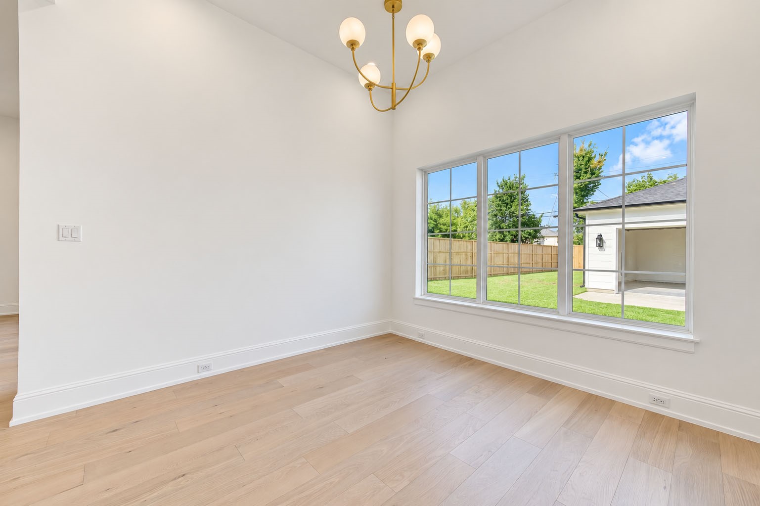 2309 Hollister Road Houston, TX 77080 - Photo 14 of 47 Another view of the sun-filled breakfast room highlights its generous proportions, wide-plank flooring, and elegant statement chandelier. A large picture window frames views of the backyard and fills the space with natural light, creating an inviting spot for leisurely breakfasts, casual meals, and relaxed conversation.