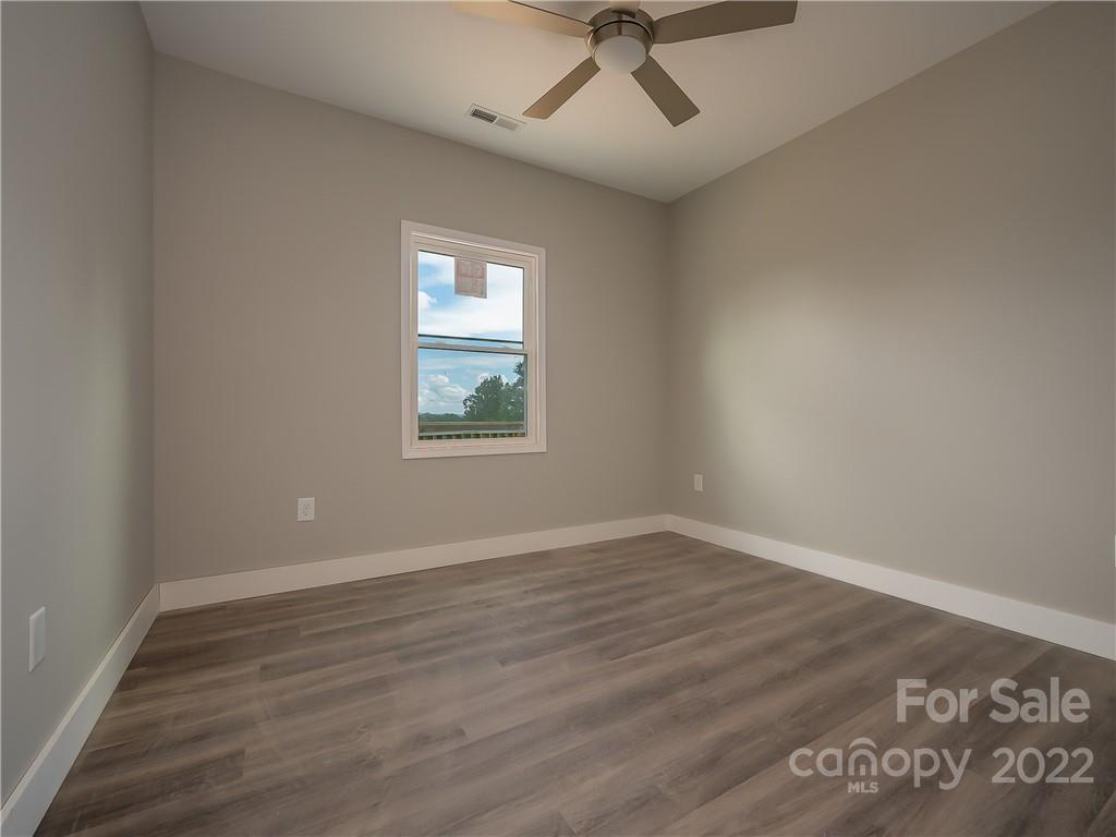 39 Hamilton Acrs Drive Tryon, NC 28782 - Photo 8 of 25 an empty room with wooden floor fan and windows